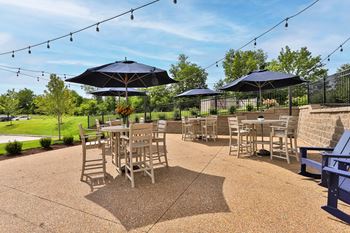 a patio with tables and chairs and umbrellas  at Aventura at Hawk Ridge, Missouri